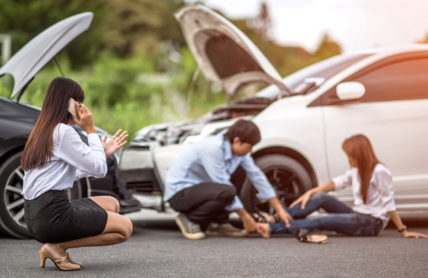 Plazo para reclamar una indemnización por accidente de tráfico Personas atendiendo a una mujer herida tras un accidente de tráfico, imagen ilustrativa sobre el plazo para reclamar una indemnización.