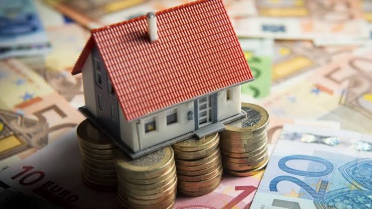 Revisar una hipoteca y proteger los derechos del consumidor Vivienda en miniatura sobre monedas y billetes de euro, imagen ilustrativa sobre la revisión de una hipoteca y los derechos del consumidor.